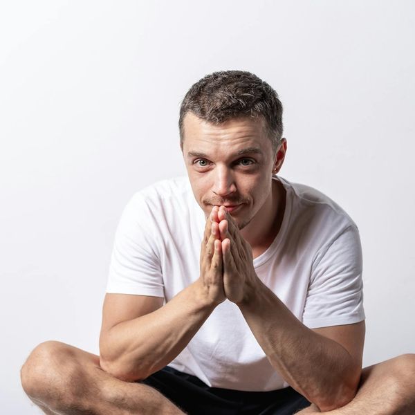A serene individual meditating in a cross-legged yoga pose with a calm expression.
